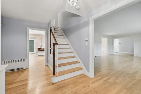 a view of a hallway with wooden floor and staircase