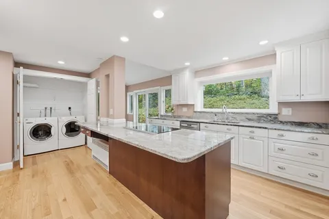 a kitchen with stainless steel appliances granite countertop a sink stove and cabinets