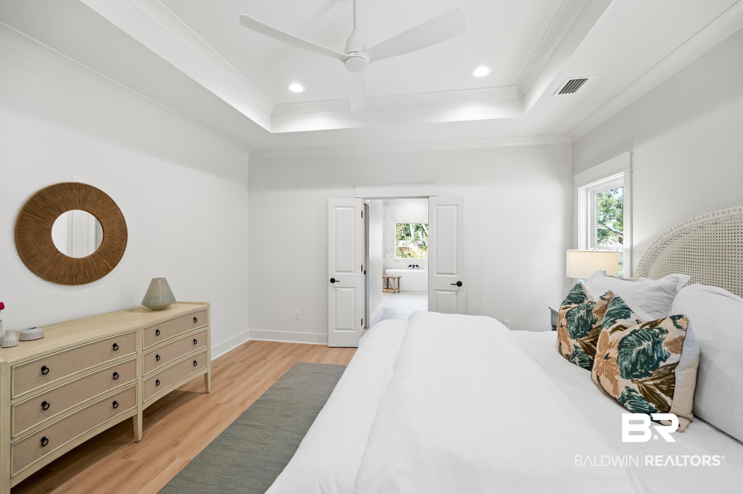 28889 Canal Road Orange Beach, AL 36561 - Photo 35 of 55 Bedroom with a tray ceiling, ceiling fan, light hardwood / wood-style flooring, and ornamental molding