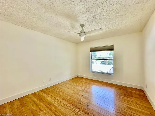 an empty room with a window and a ceiling fan