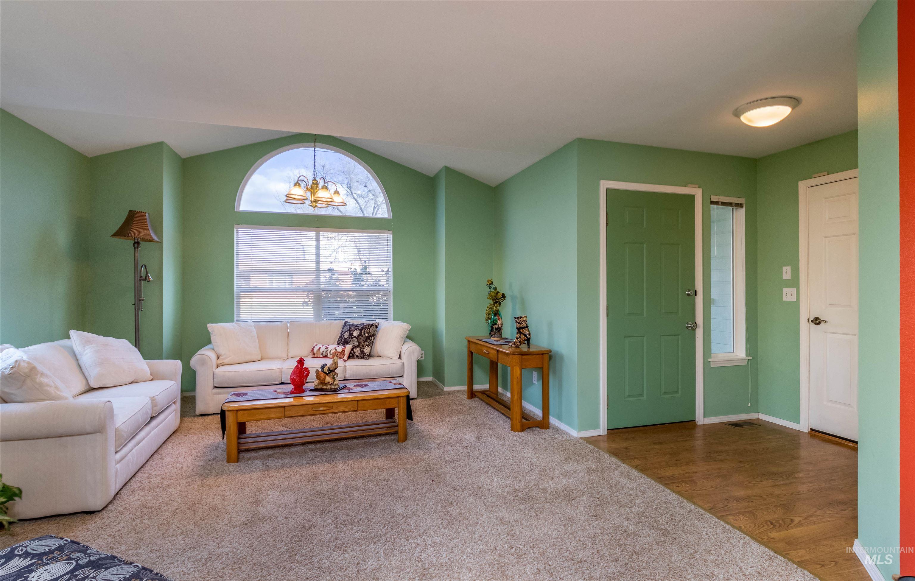 1811 Cleveland Street Boise, ID 83705 - Photo 6 of 30 Living room with carpet, vaulted ceiling, a chandelier, and wood finished floors