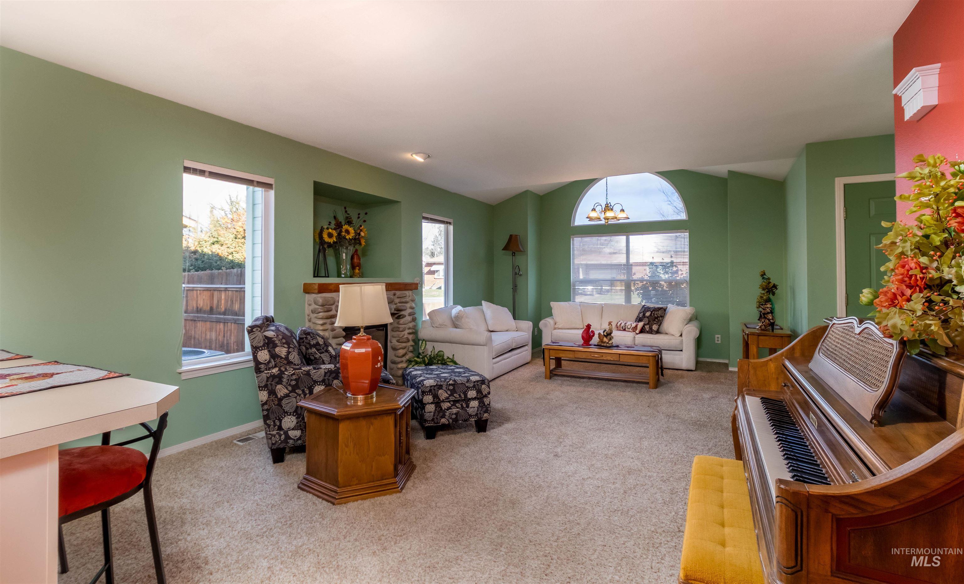 1811 Cleveland Street Boise, ID 83705 - Photo 8 of 30 Living room with light colored carpet, a chandelier, lofted ceiling, and healthy amount of natural light