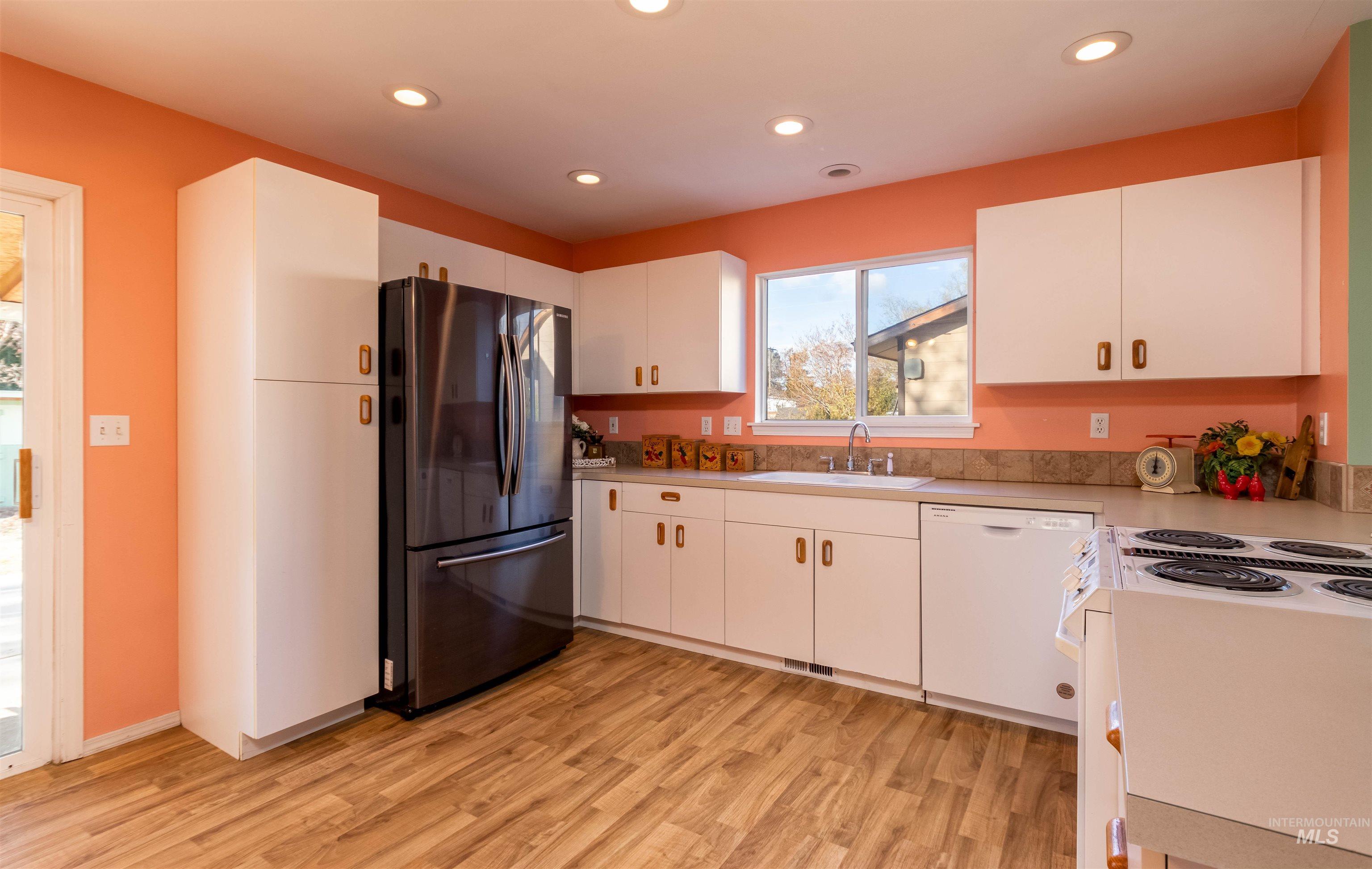 1811 Cleveland Street Boise, ID 83705 - Photo 9 of 30 Kitchen with white appliances, light countertops, white cabinetry, light wood-type flooring, and recessed lighting