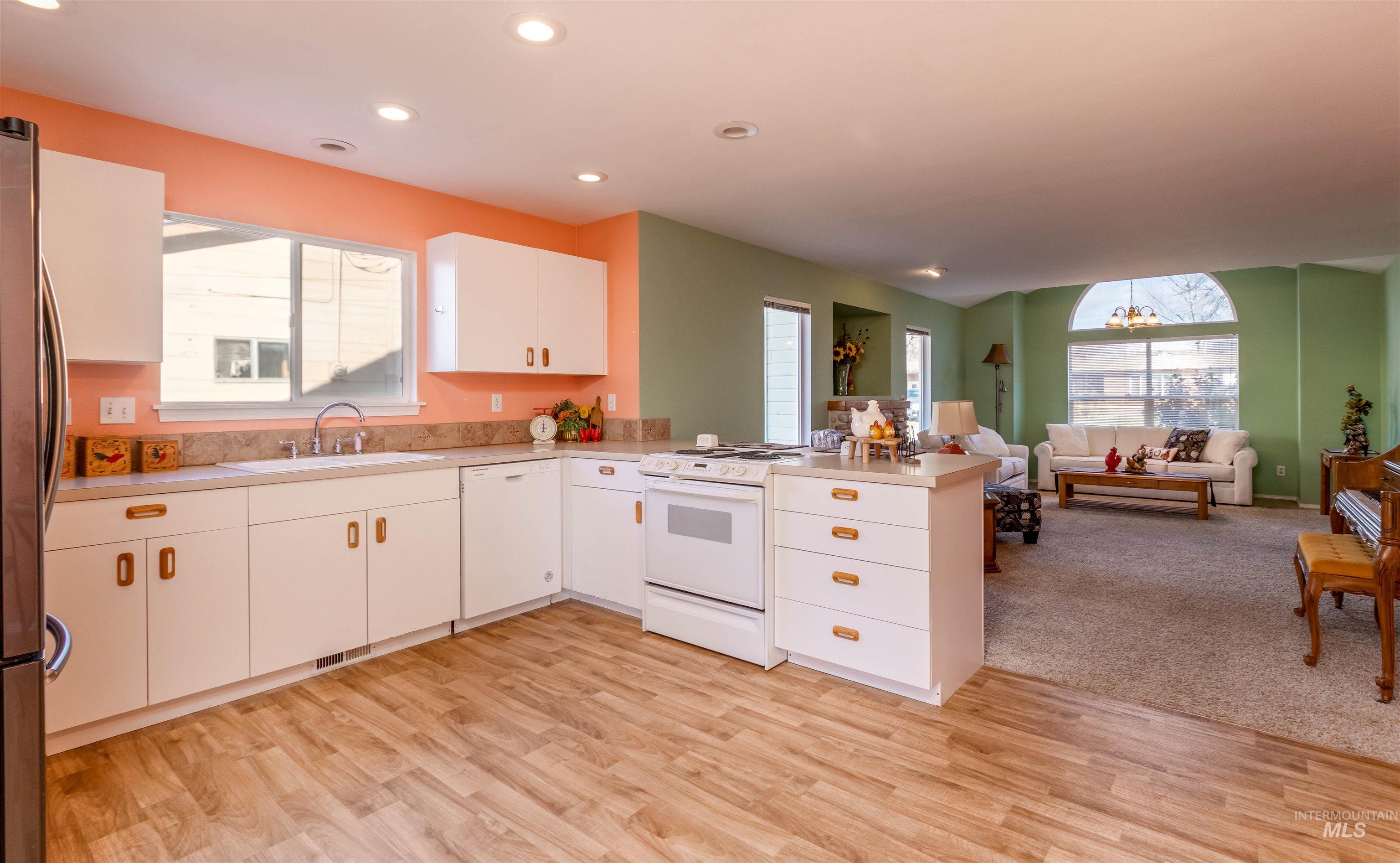 1811 Cleveland Street Boise, ID 83705 - Photo 29 of 30 Kitchen with light countertops, white appliances, white cabinetry, open floor plan, and recessed lighting