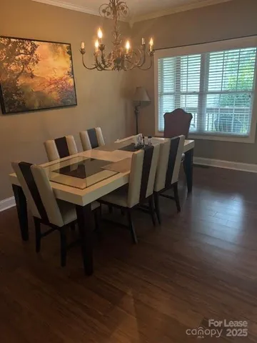 a view of a dining room with furniture a chandelier and wooden floor
