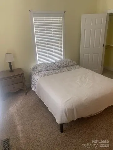 a bed sitting in a bedroom next to a window