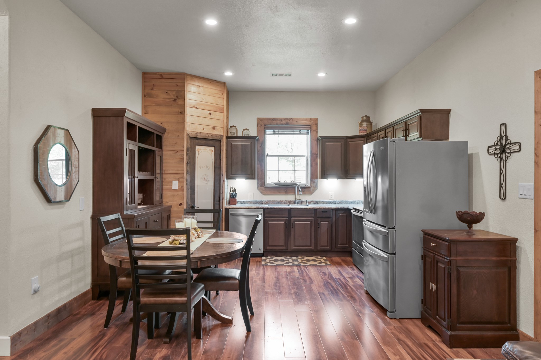 15306 Rabon Chapel Road Montgomery, TX 77316 - Photo 15 of 48 a kitchen with stainless steel appliances a refrigerator a stove a dining table and chairs with wooden floor