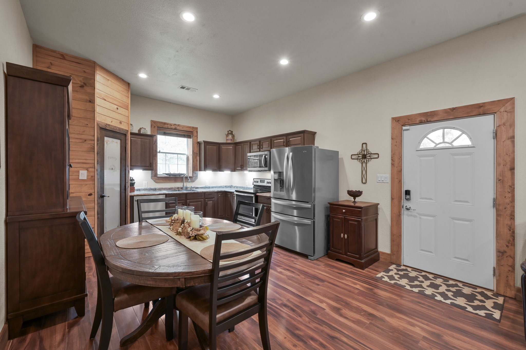 15306 Rabon Chapel Road Montgomery, TX 77316 - Photo 16 of 48 a kitchen with stainless steel appliances kitchen island granite countertop a refrigerator a stove a kitchen island and chairs with wooden floor