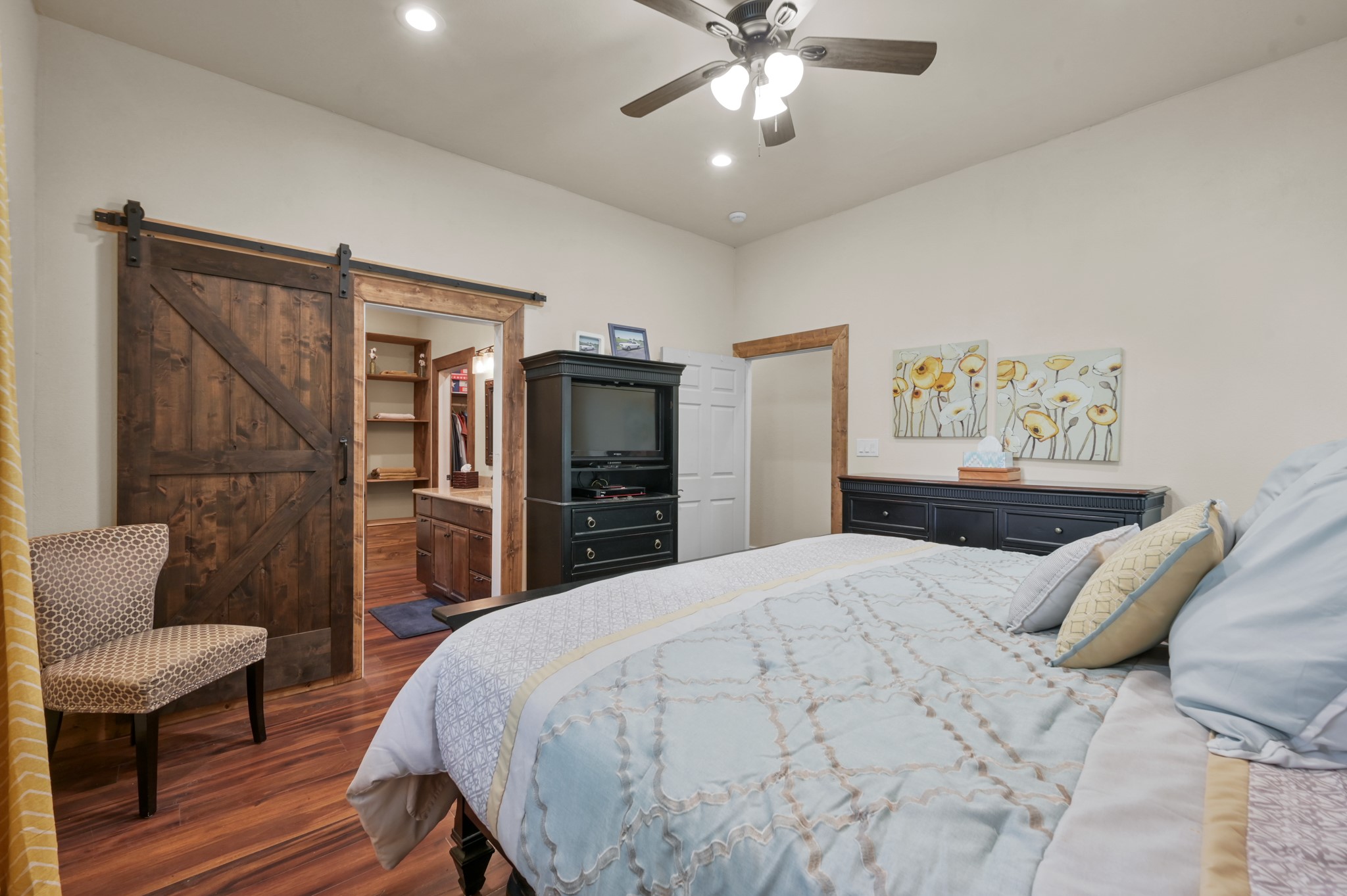 15306 Rabon Chapel Road Montgomery, TX 77316 - Photo 26 of 48 a bedroom with a bed and a chandelier