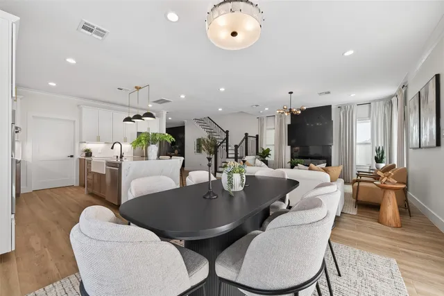 a living room with furniture kitchen view and a chandelier