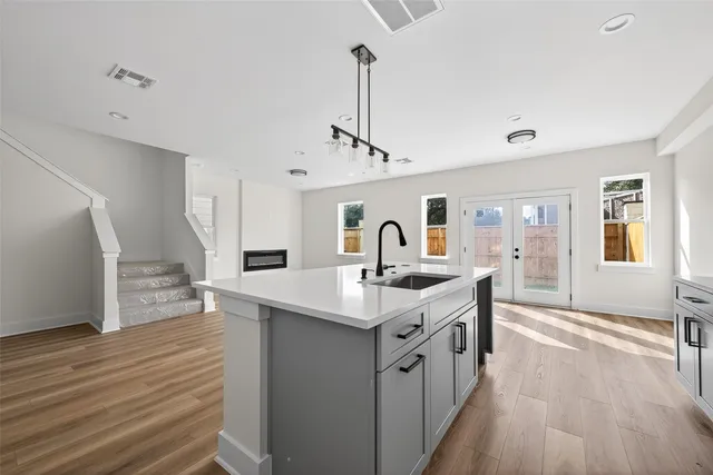 a large room with kitchen island a sink a counter space and living room view
