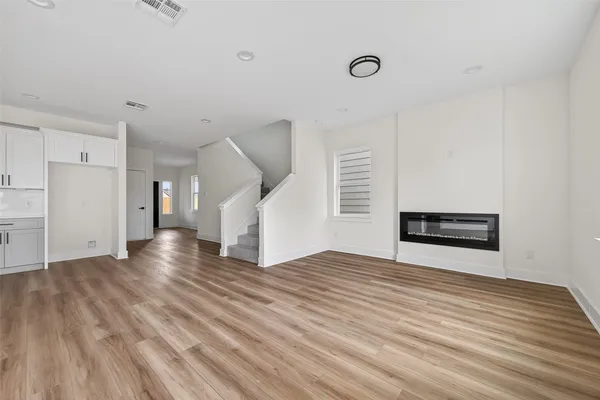 a view of empty room with wooden floor
