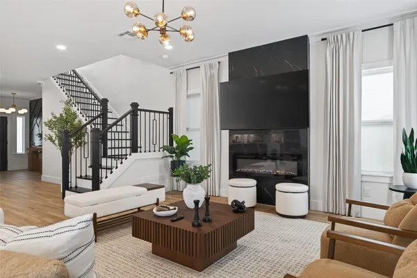 a living room with furniture a chandelier and a rug