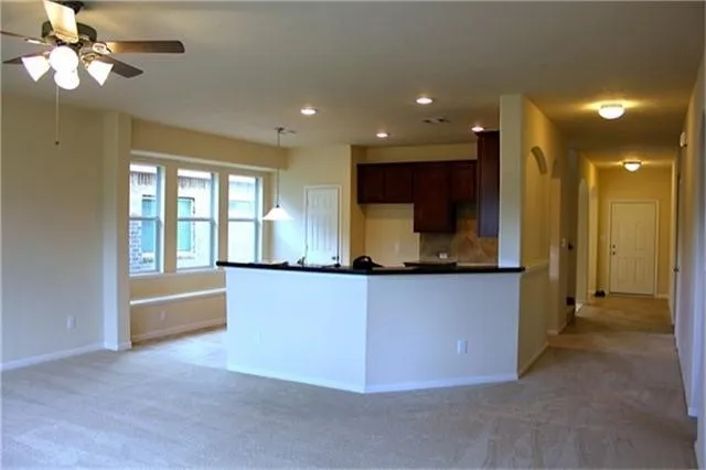 a view of kitchen with granite countertop cabinets and refrigerator