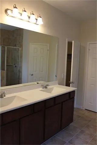 a bathroom with a double vanity sink and a mirror