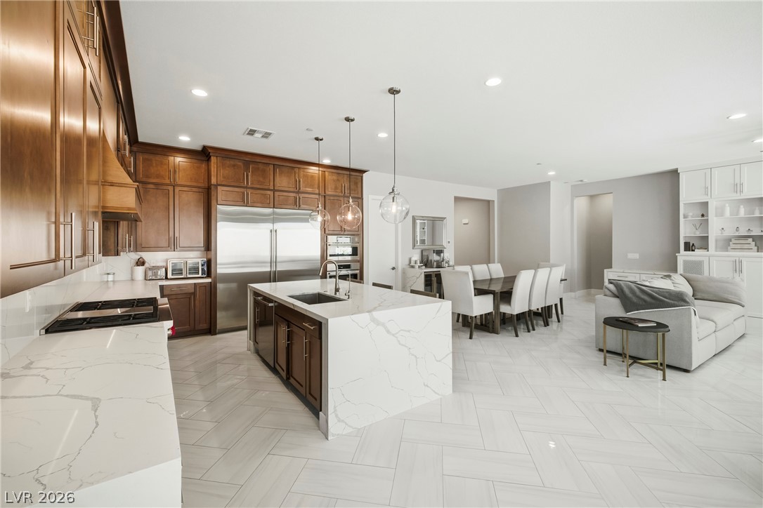 45 Garibaldi Way Henderson, NV 89011 - Photo 19 of 74 An open-concept living area features a grand kitchen island and a well-lit dining space, perfect for entertaining.