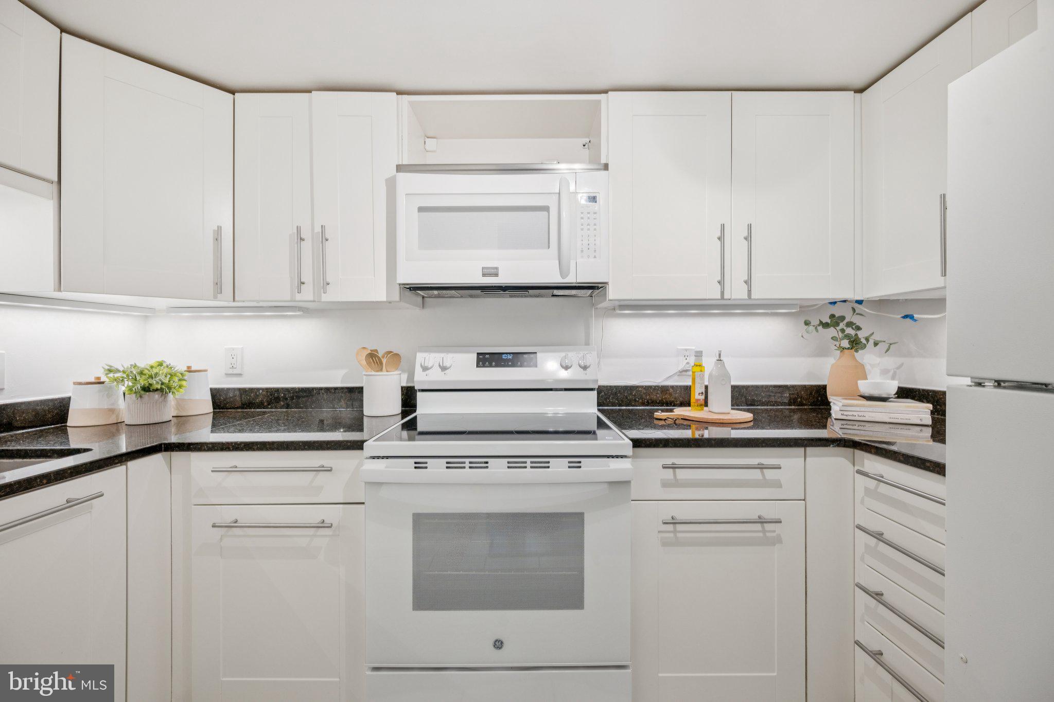 2630 Adams Mill Road Northwest, Unit 103 Washington, DC 20009 - Photo 6 of 24 a kitchen with granite countertop white cabinets and white appliances