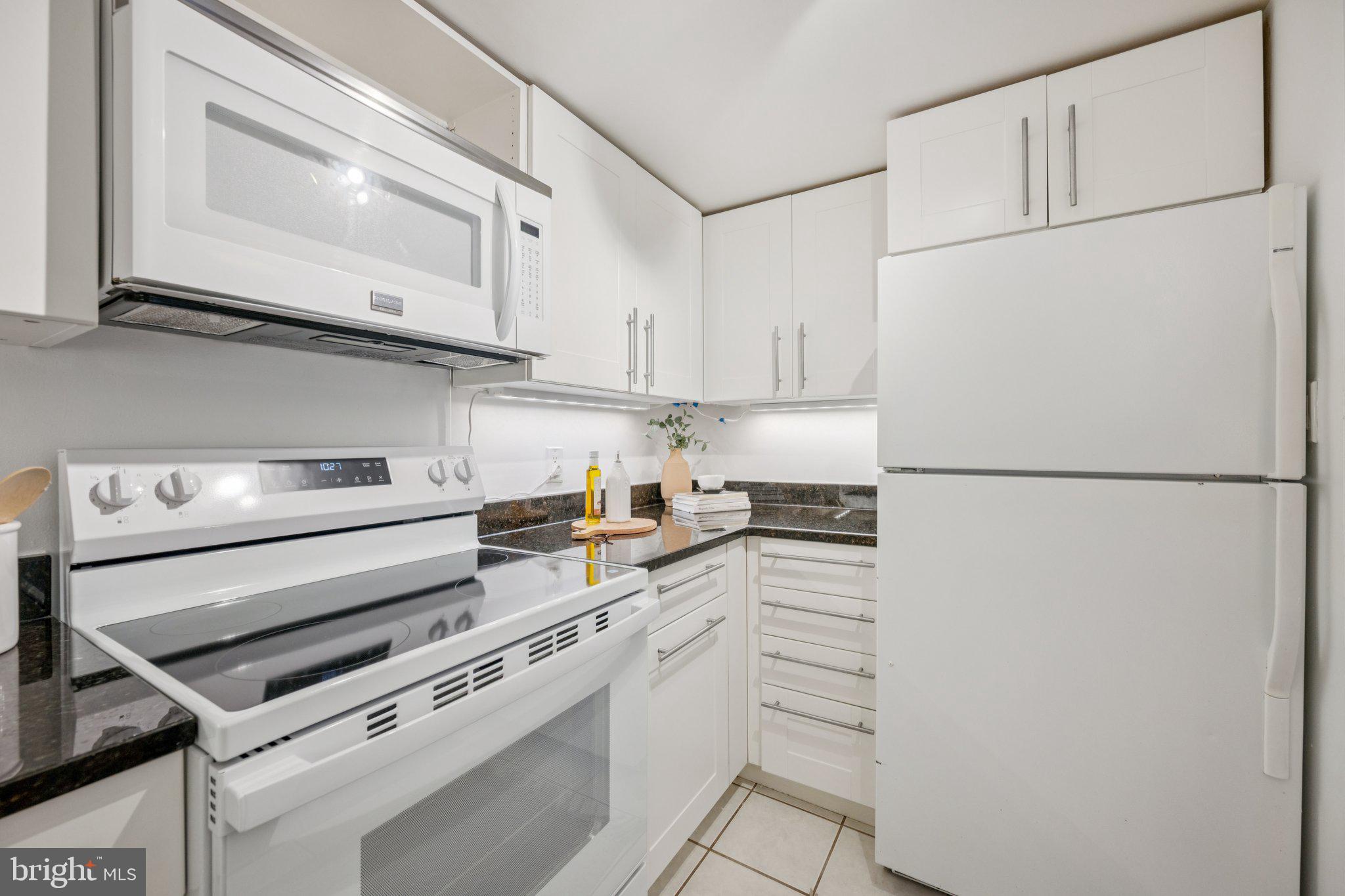 2630 Adams Mill Road Northwest, Unit 103 Washington, DC 20009 - Photo 9 of 24 a kitchen with stainless steel appliances a refrigerator sink and cabinets