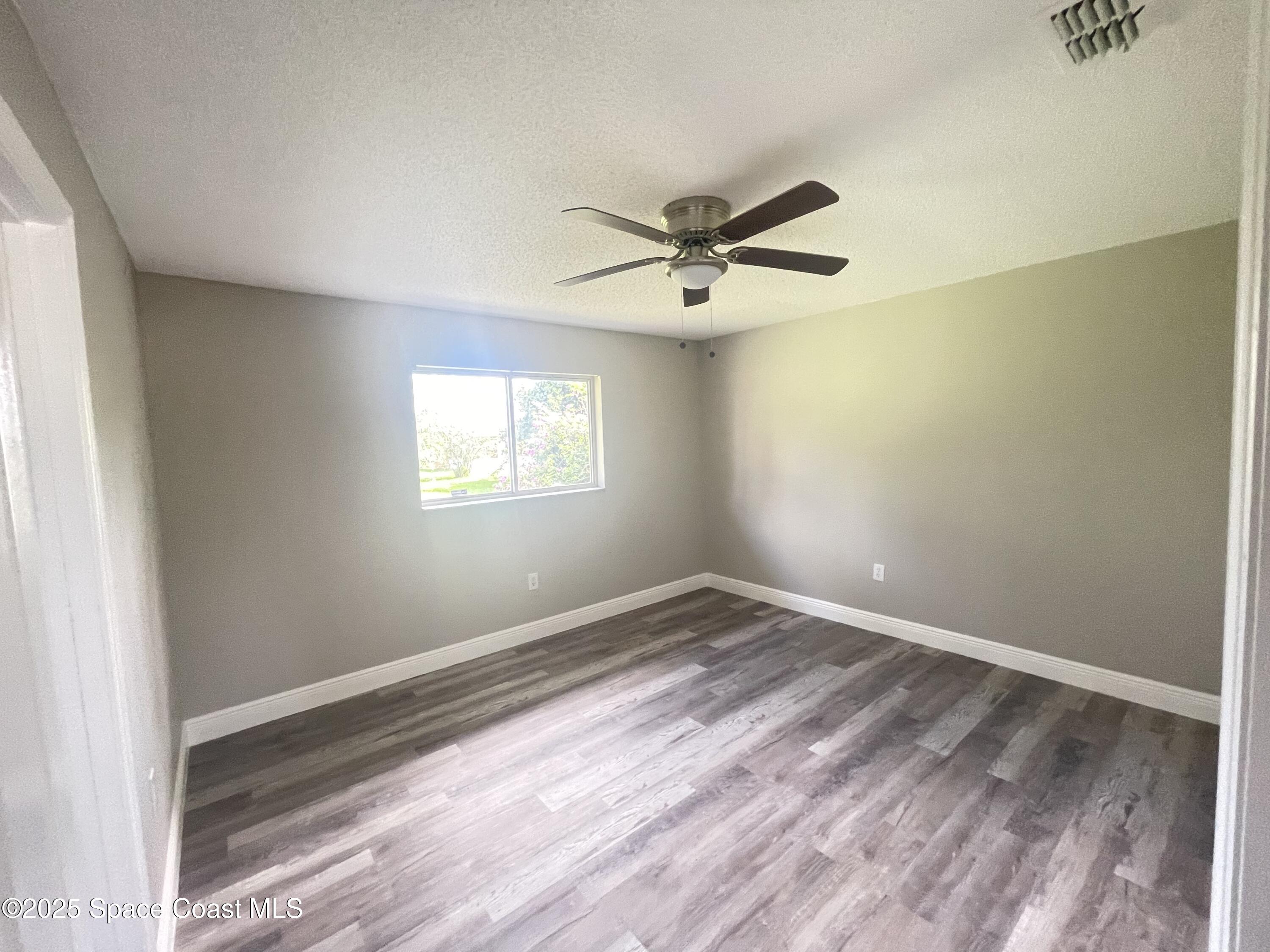1118 Manatee Drive Rockledge, FL 32955 - Photo 11 of 17 a view of a big room with wooden floor and windows
