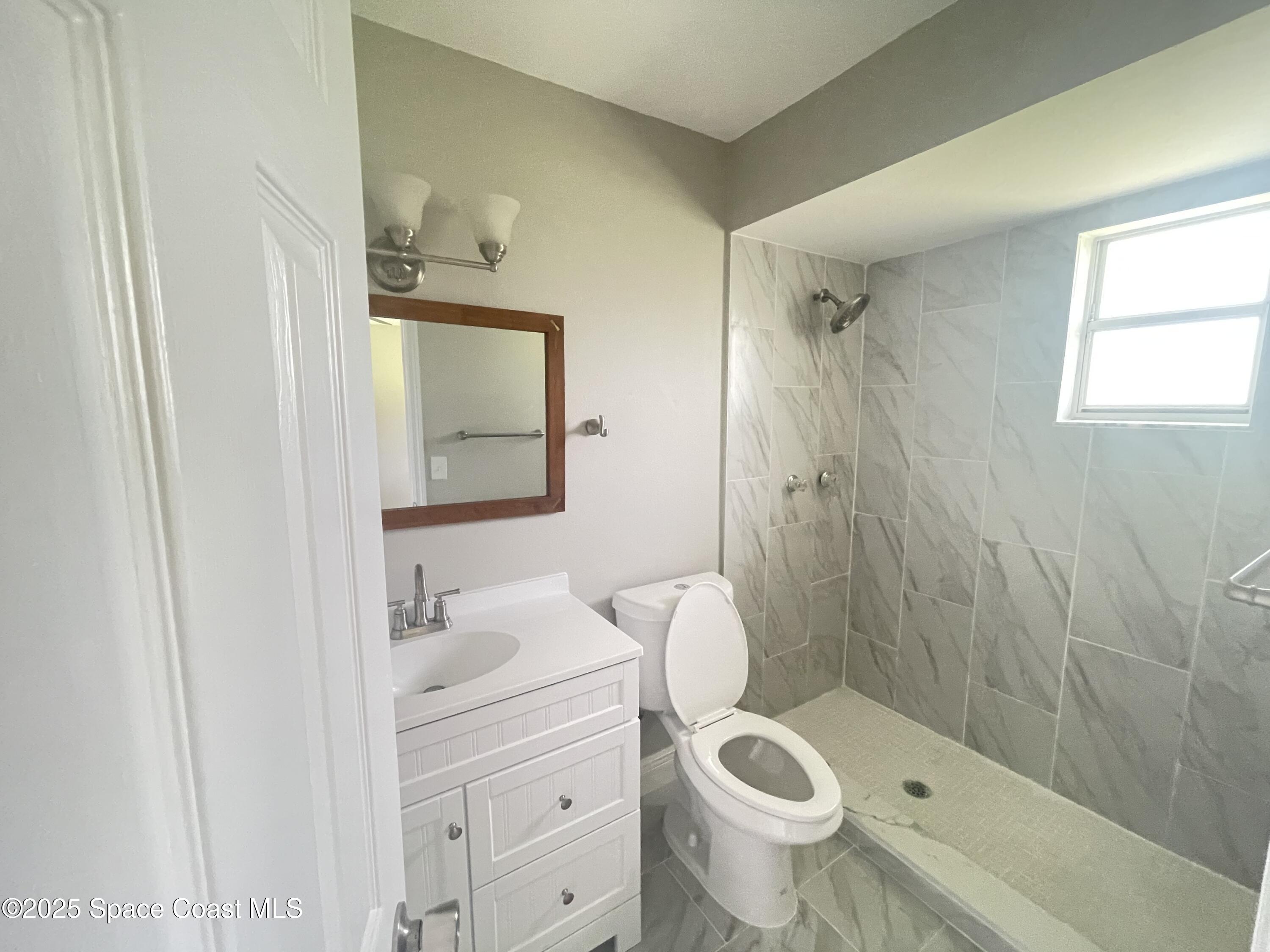 1118 Manatee Drive Rockledge, FL 32955 - Photo 13 of 17 a bathroom with a sink a toilet and shower