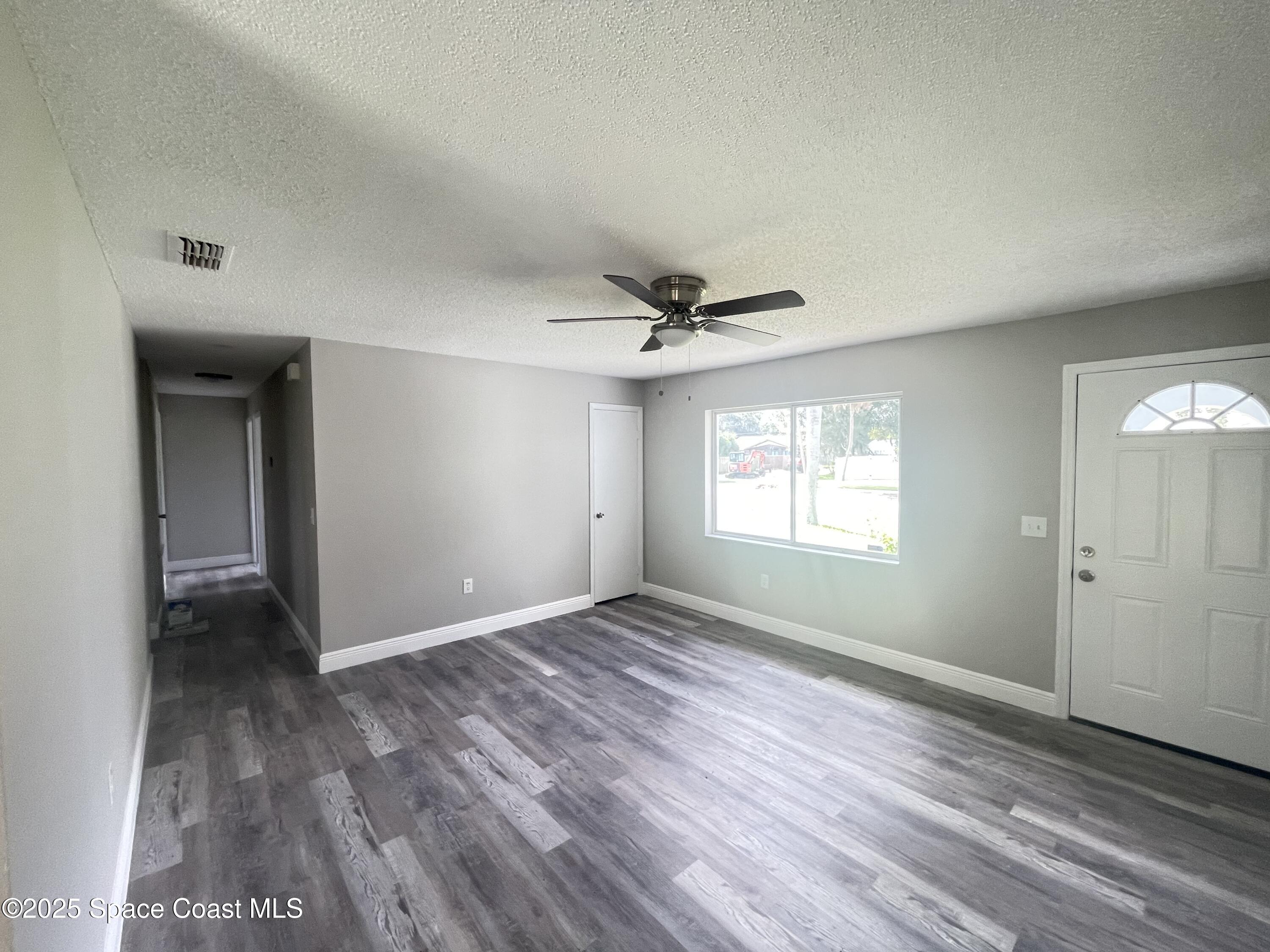 1118 Manatee Drive Rockledge, FL 32955 - Photo 5 of 17 an empty room with wooden floor and windows