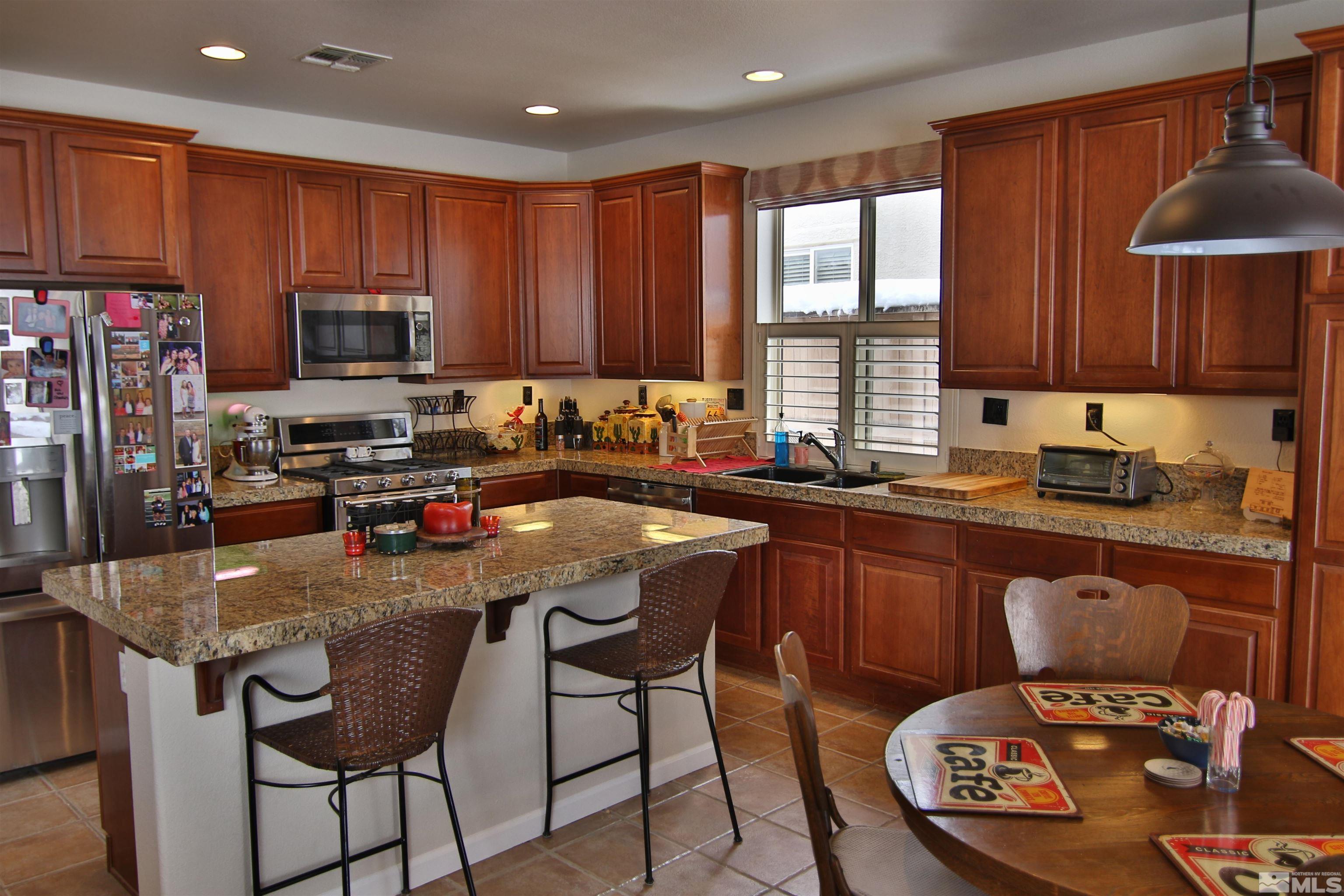 10640 Fire Poppy Circle Reno, NV 89521 - Photo 3 of 27 a kitchen with a stove a sink a microwave a refrigerator and cabinets