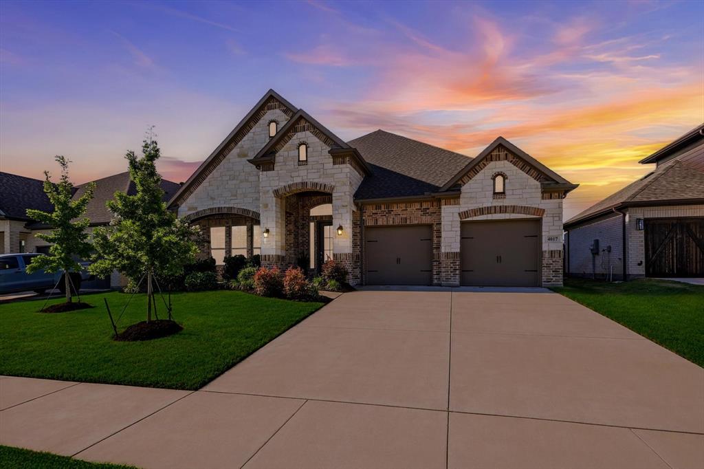 4017 Eagles Bluff Road Midlothian, TX 76065 - Photo 1 of 38 Stone and brick facade home featuring a two-car garage, arched entryways, and mature landscaping