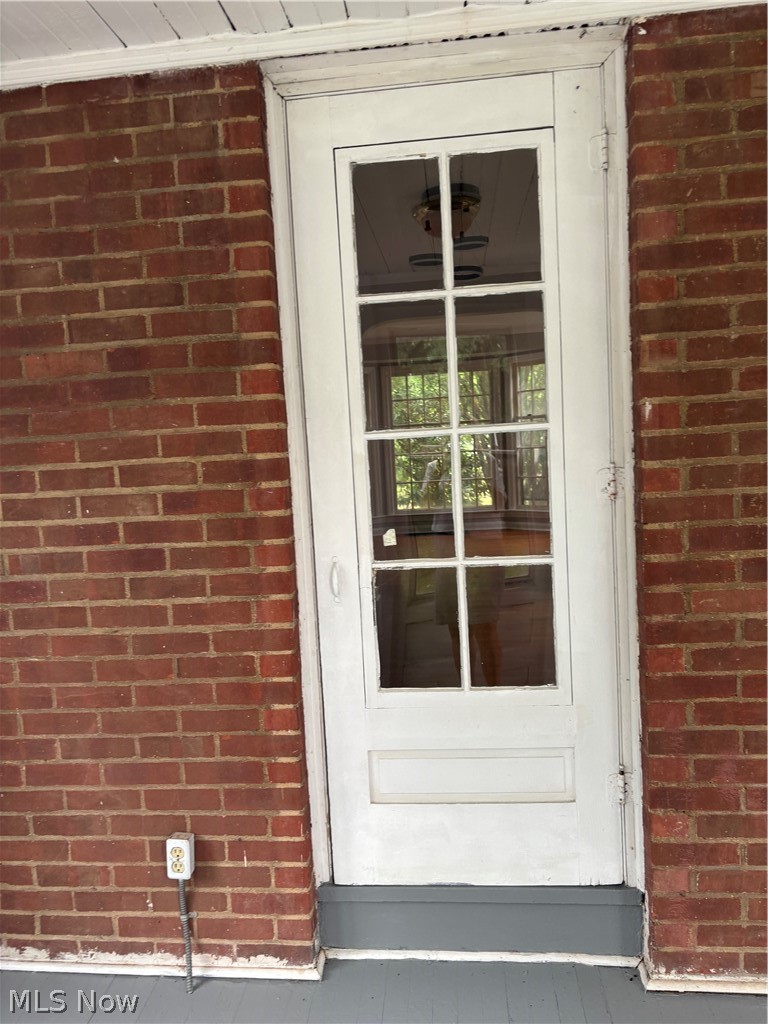 3830 Berkeley Road Cleveland Heights, OH 44118 - Photo 22 of 27 White multi-pane door set within a brick exterior from the dinning room to the enclosed porch