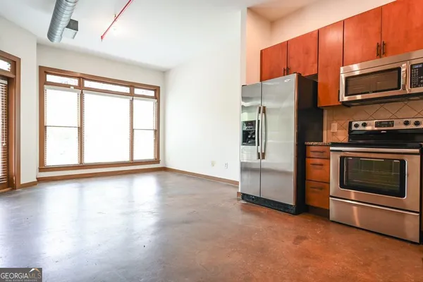 a kitchen with stainless steel appliances a stove a microwave and a hard wood floors