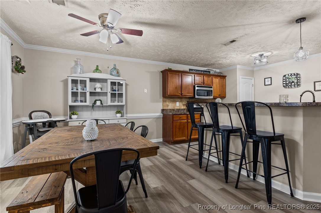 9619 Rockfish Road Raeford, NC 28376 - Photo 12 of 47 a view of a dining room with furniture and wooden floor