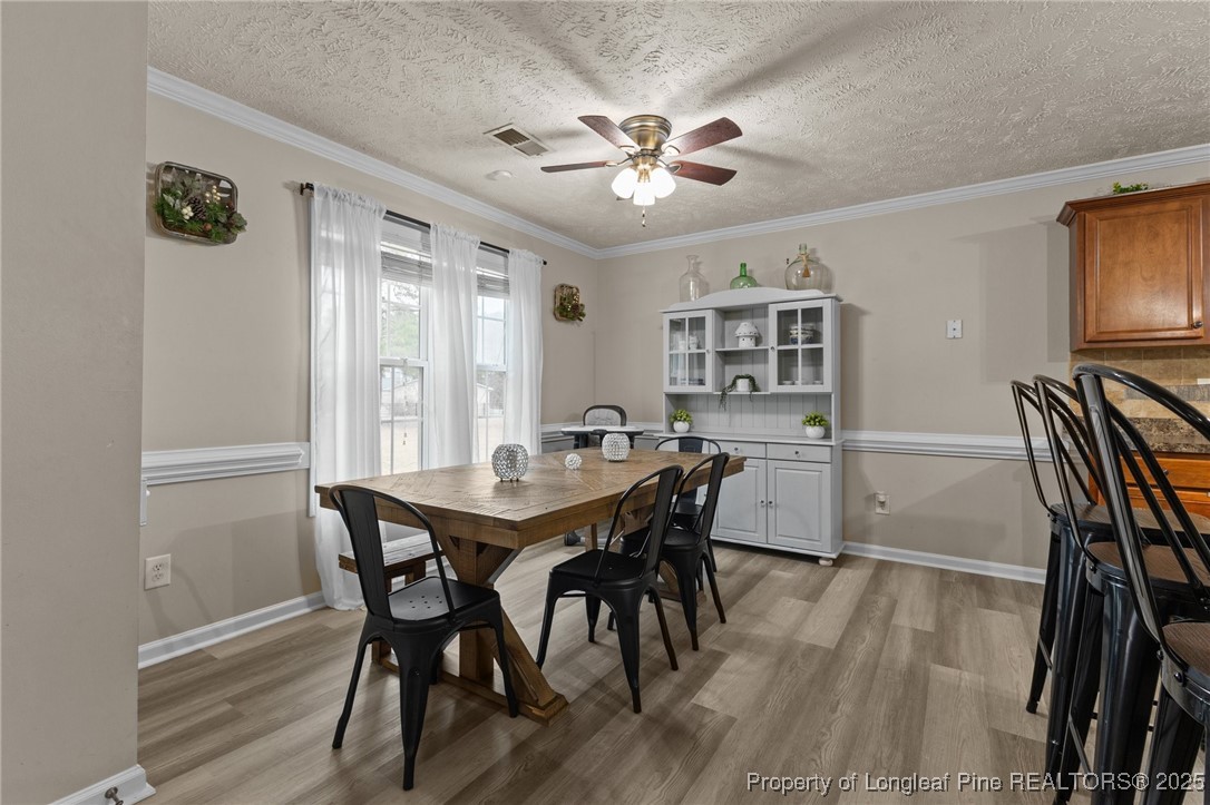 9619 Rockfish Road Raeford, NC 28376 - Photo 13 of 47 a view of a dining room with furniture and wooden floor