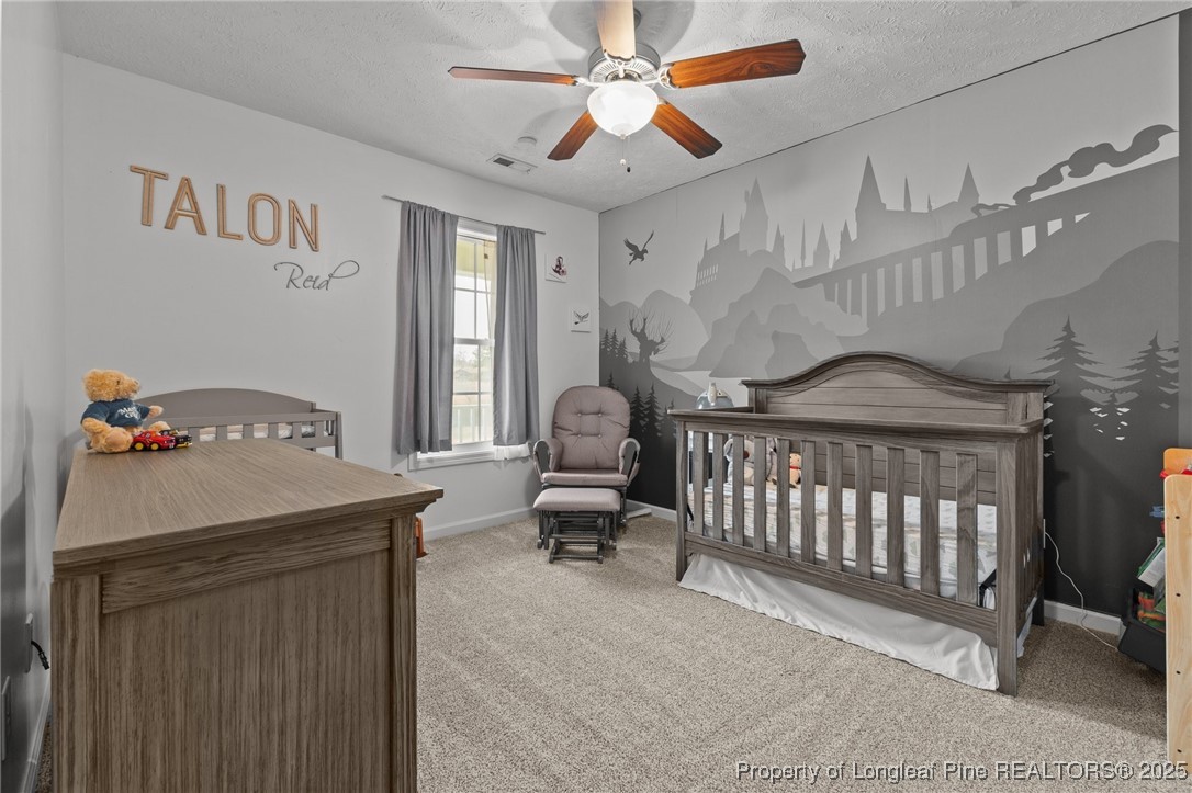 9619 Rockfish Road Raeford, NC 28376 - Photo 25 of 47 a bedroom with a bed and a chandelier