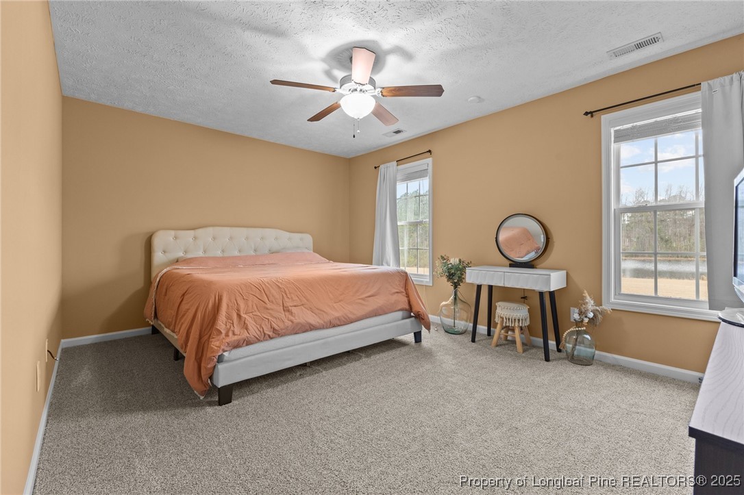 9619 Rockfish Road Raeford, NC 28376 - Photo 27 of 47 a bedroom with a bed and a chandelier
