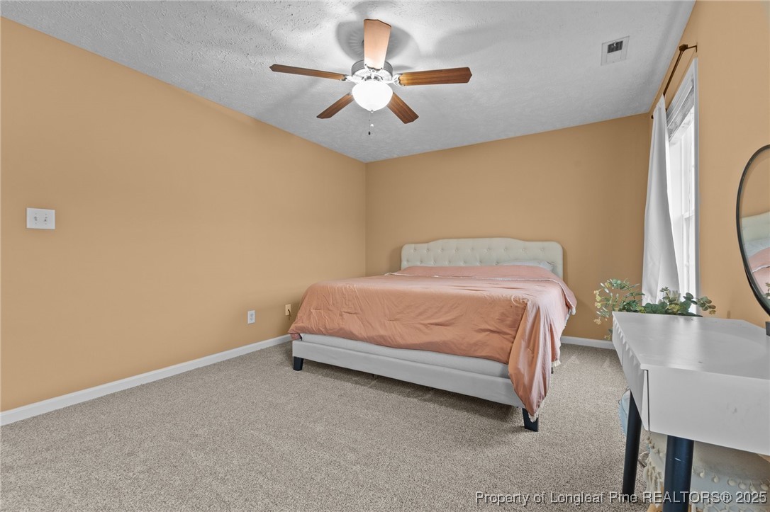 9619 Rockfish Road Raeford, NC 28376 - Photo 28 of 47 a bedroom with a bed and a chandelier