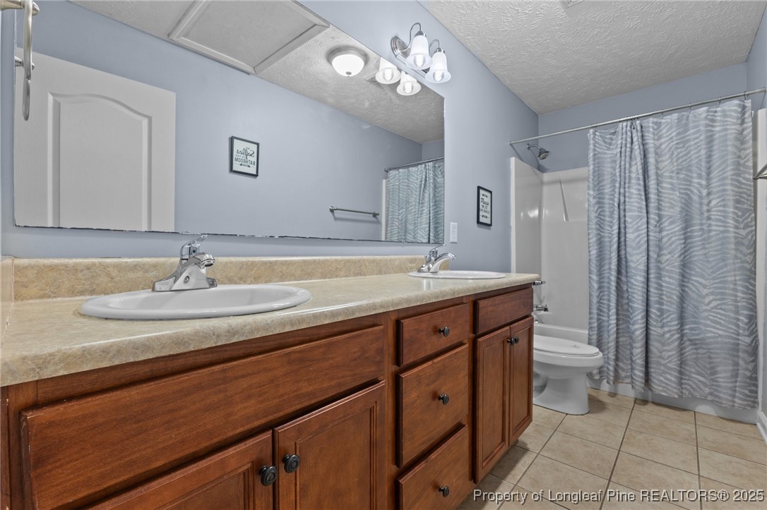 9619 Rockfish Road Raeford, NC 28376 - Photo 29 of 47 a bathroom with a double vanity sink and a toilet