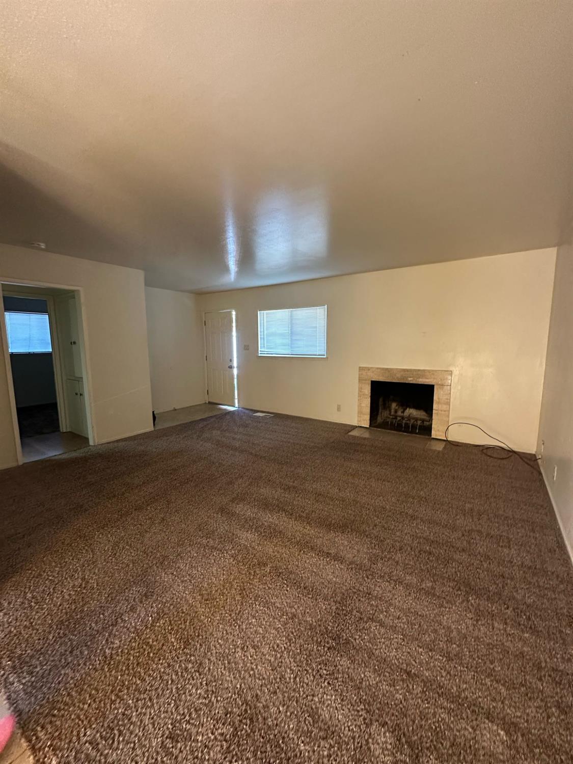 114 College Avenue Modesto, CA 95350 - Photo 9 of 19 a view of empty room with window and fireplace