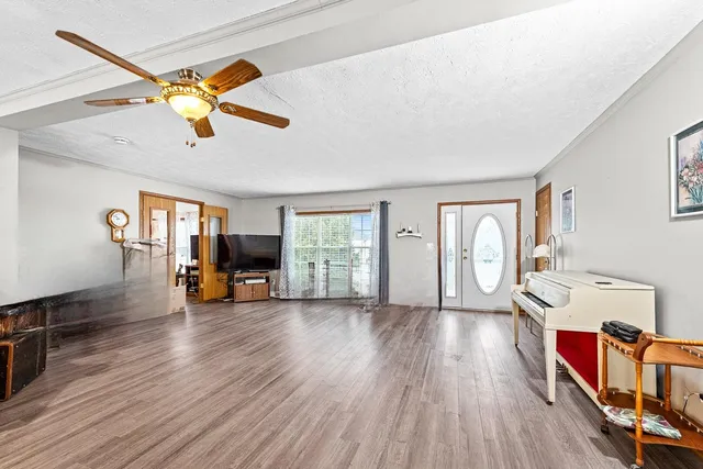 a view of an empty room with window and wooden floor