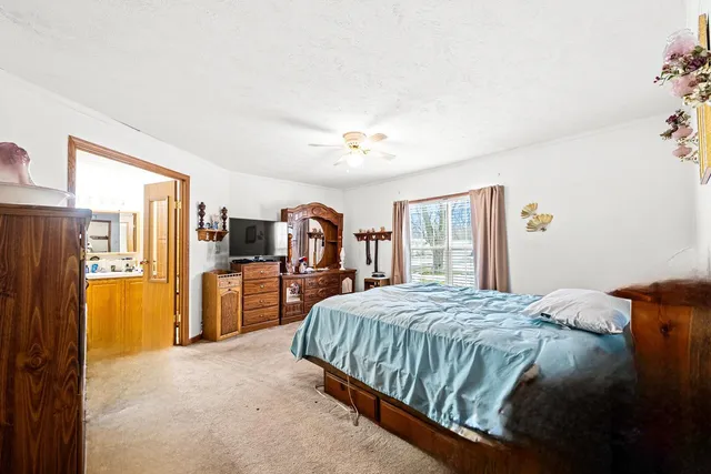 a bedroom with a large bed a flat tv screen and dresser