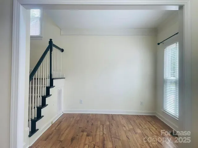 a view of hallway with stairs and wooden floor
