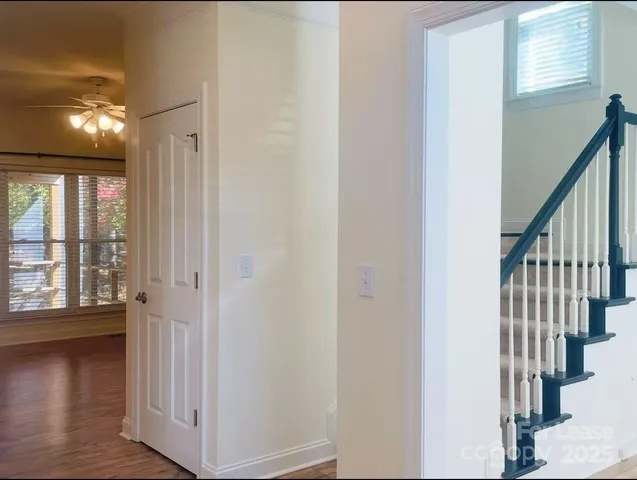 a view of a hallway with wooden floor and staircase