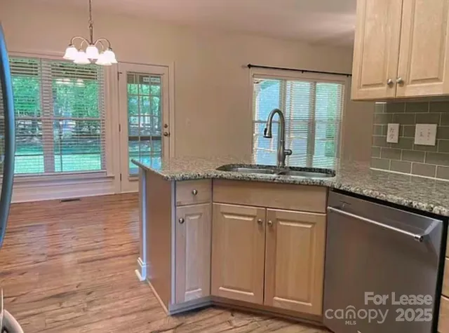 a kitchen with granite countertop a stove a sink and a granite counter top