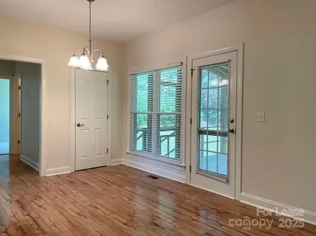a view of a room with wooden floor and entryway