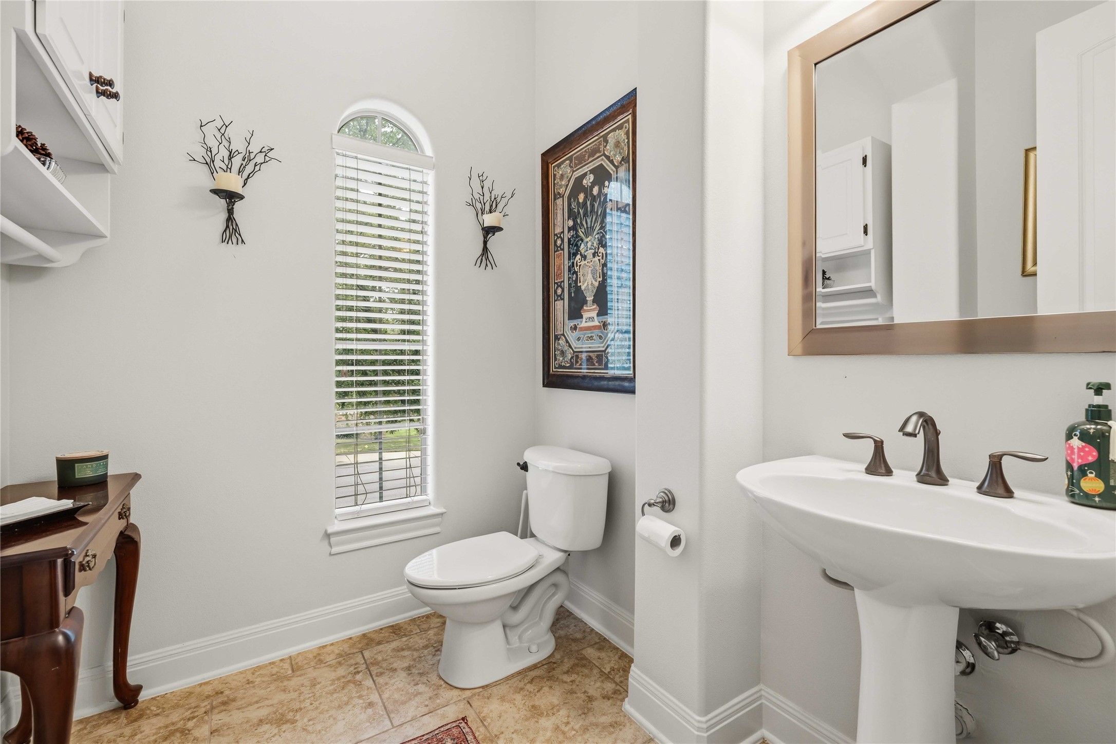15200 Spillman Ranch Loop Austin, TX 78738 - Photo 15 of 40 Half Guest Bathroom featuring a pedestal sink with bronze fixtures, a toilet, and a window providing natural light