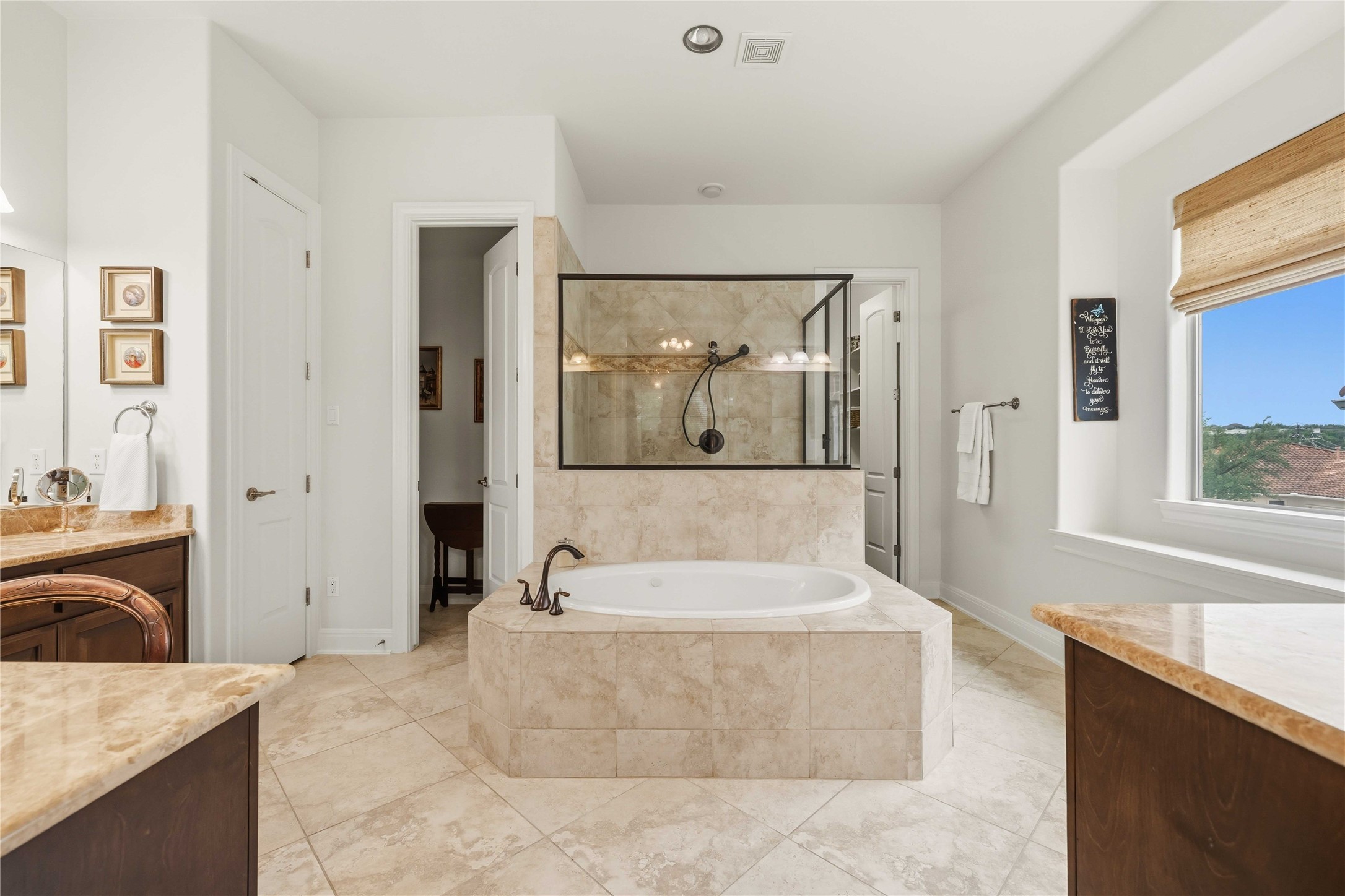 15200 Spillman Ranch Loop Austin, TX 78738 - Photo 18 of 40 Primary bathroom features a large soaking tub with surrounding tile, a glass-enclosed shower, and a vanity with a mirror