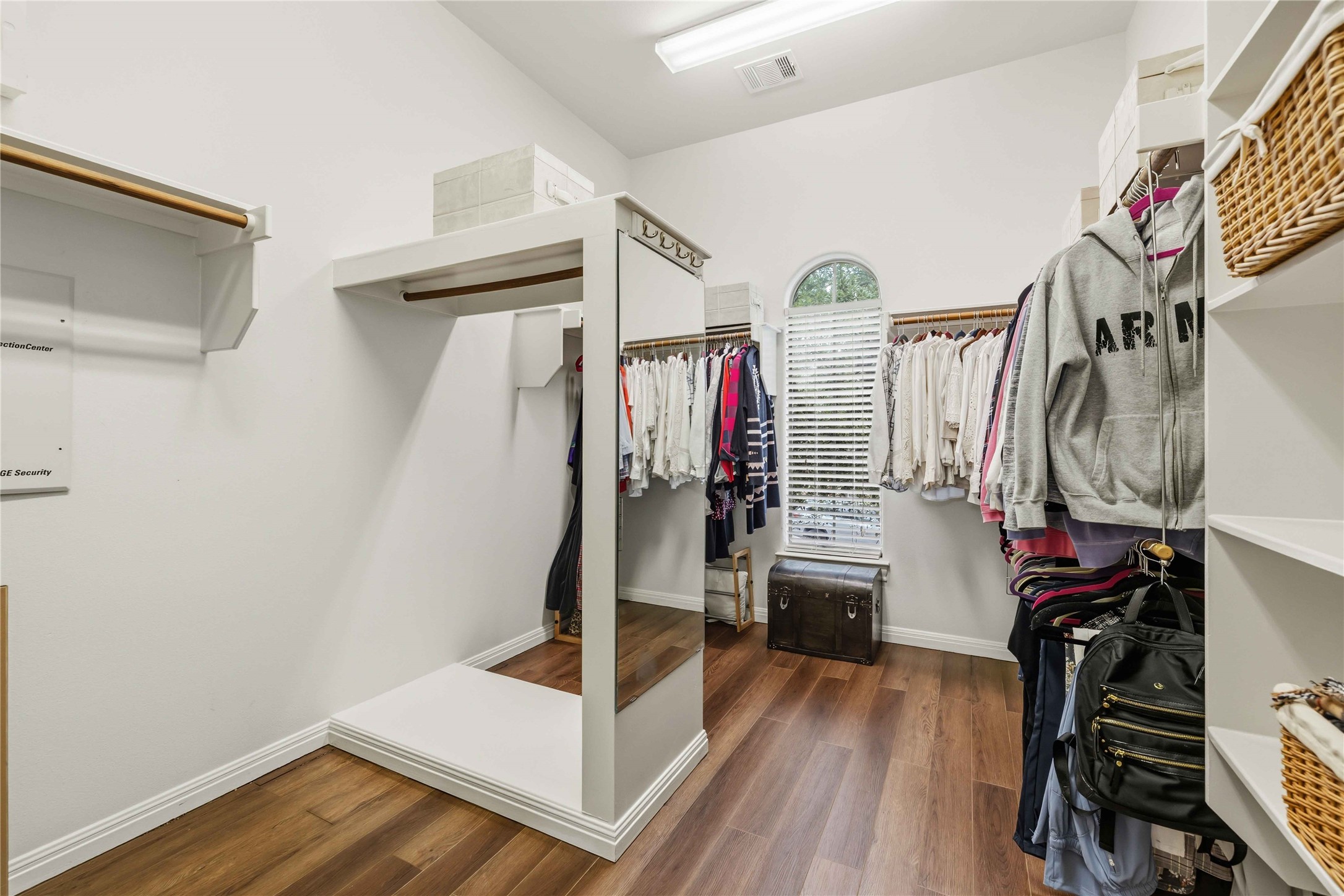 15200 Spillman Ranch Loop Austin, TX 78738 - Photo 20 of 40 Spacious walk-in closet featuring wood flooring, a window with blinds, and built-in shelving with hanging rods