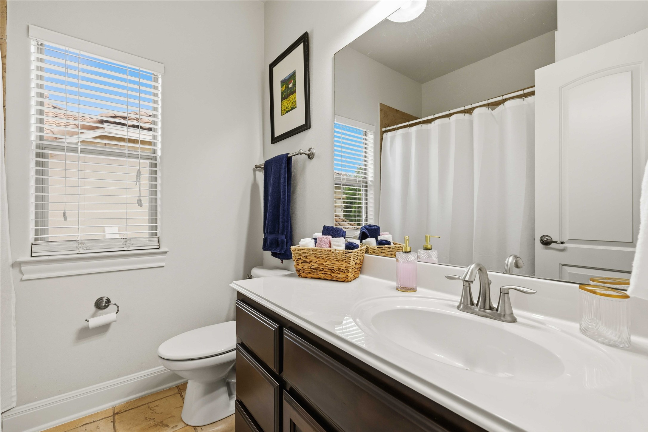 15200 Spillman Ranch Loop Austin, TX 78738 - Photo 24 of 40 Bathroom features a vanity with a white countertop and a built-in sink, a large mirror, and a window with horizontal blinds