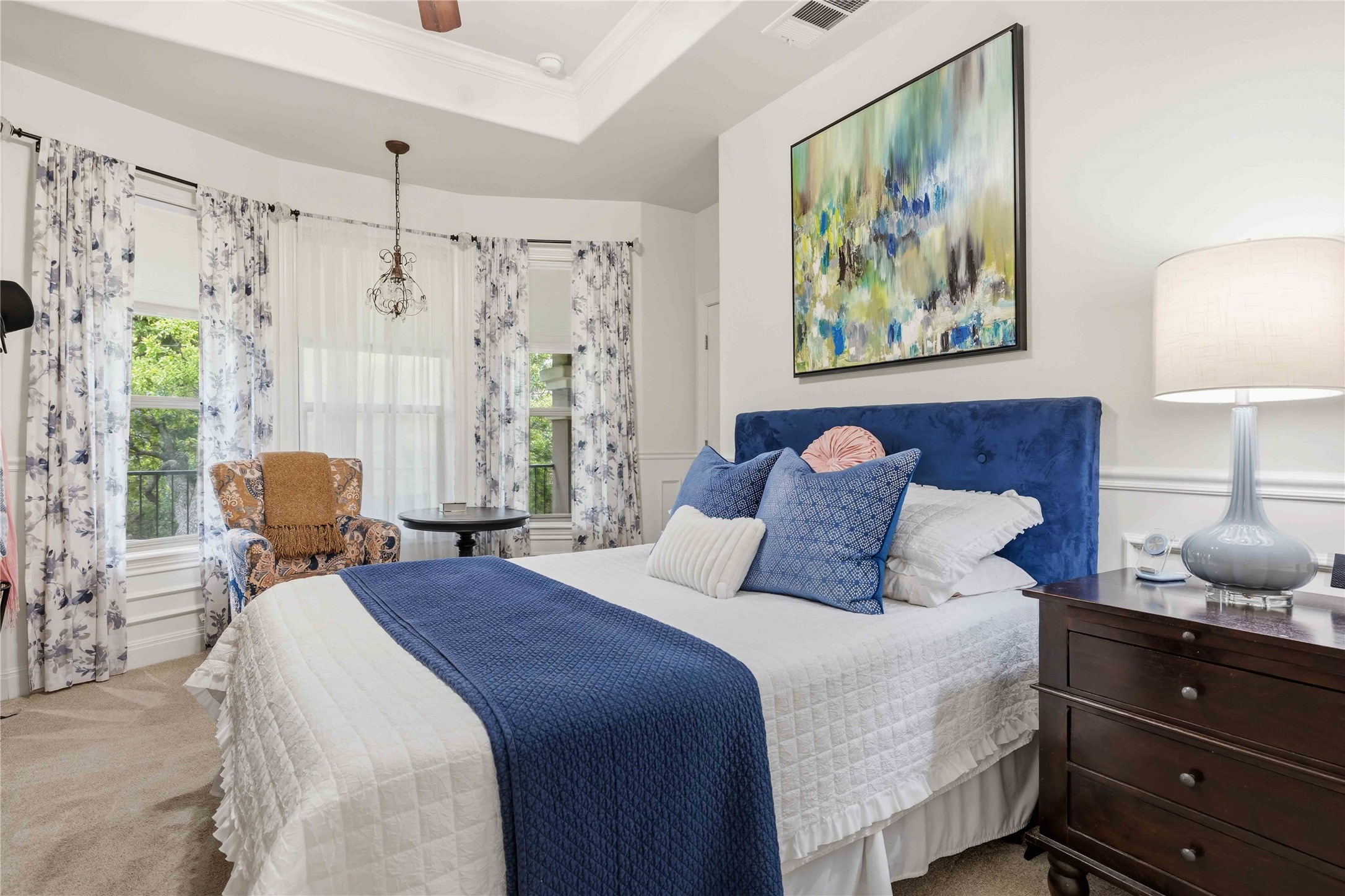 15200 Spillman Ranch Loop Austin, TX 78738 - Photo 29 of 40 The property features upstairs bedroom #5 a bay window with natural light, a ceiling fan, and a tray ceiling