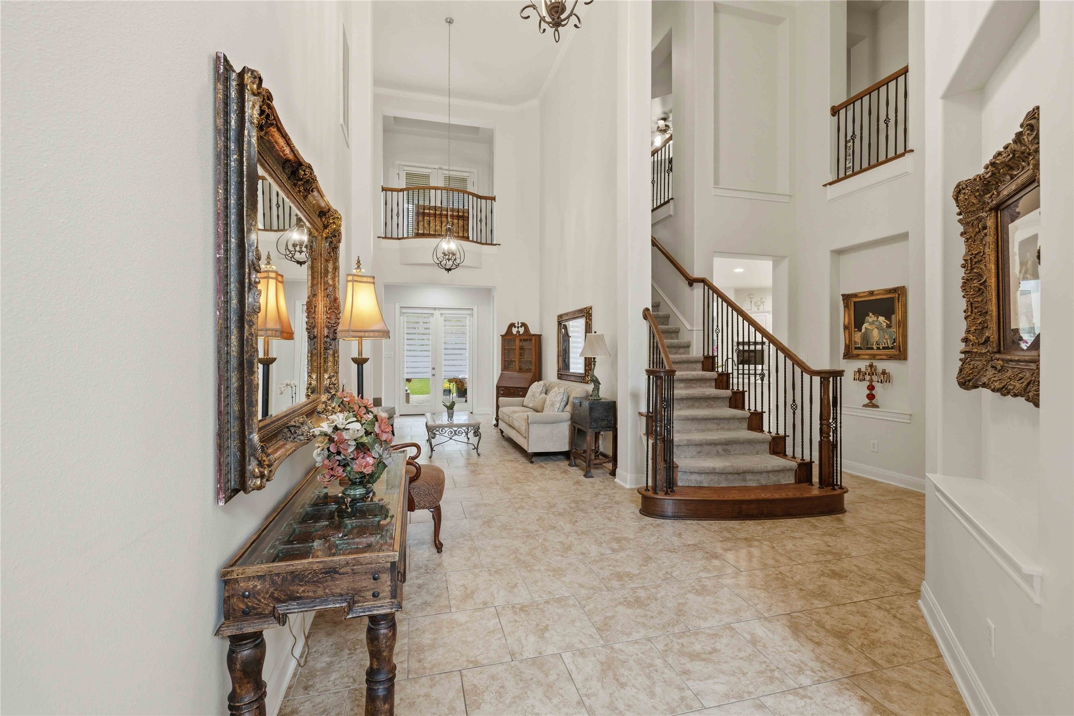 15200 Spillman Ranch Loop Austin, TX 78738 - Photo 3 of 40 The property features a grand entrance with high ceilings, tile flooring, and a carpeted staircase with dark wood and wrought iron railings