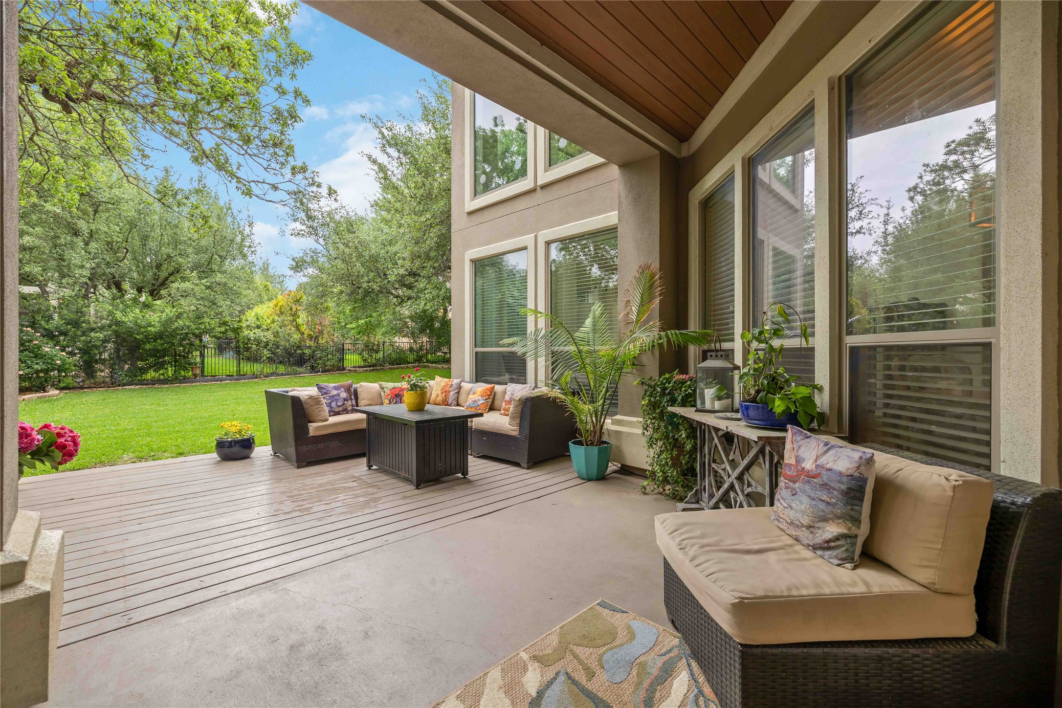 15200 Spillman Ranch Loop Austin, TX 78738 - Photo 34 of 40 The property features a covered patio with a combination of textured concrete and wood decking, overlooking a lush green lawn and mature trees