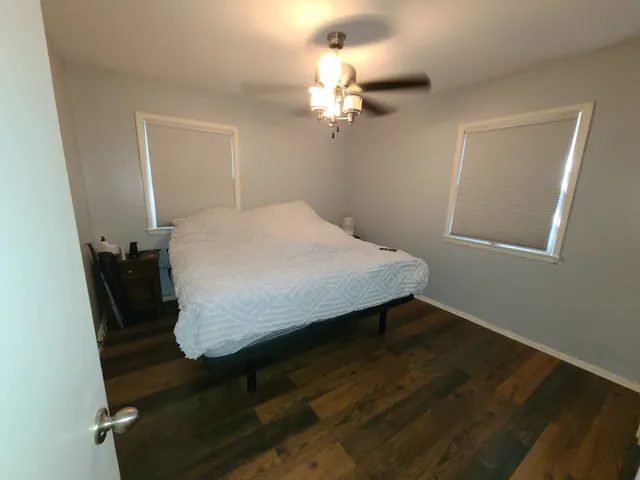 a bed sitting in a spacious bedroom next to a window